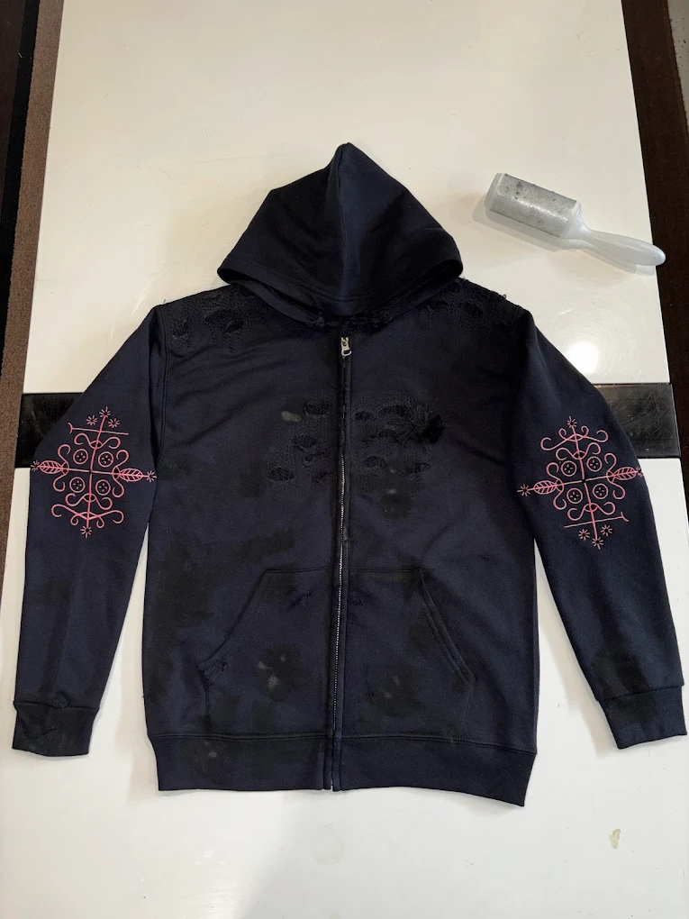 Navy zip hoodie with pink embroidered emblems on both sleeves