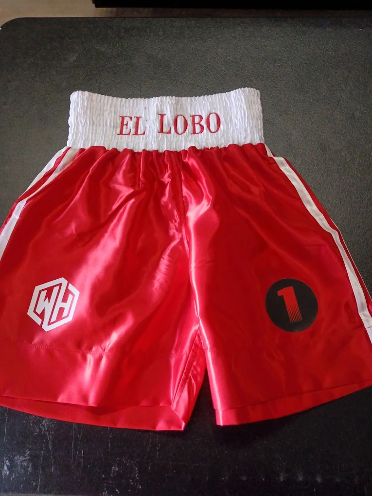 Red satin boxing trunks with EL LOBO embroidered on the white waistband